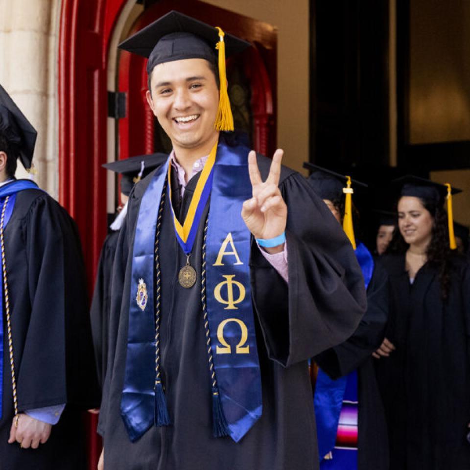 Graduating senior poses for a photo at commencement.